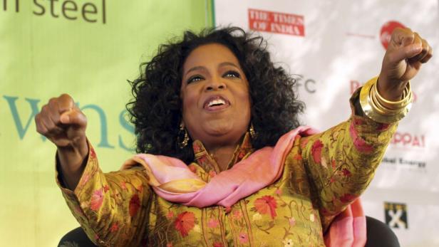 Oprah Winfrey mit erhobenen Fäusten bei einer Veranstaltung in Indien.