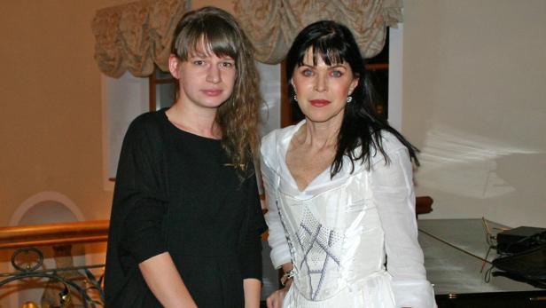 Zwei Frauen posieren vor einem Klavier.