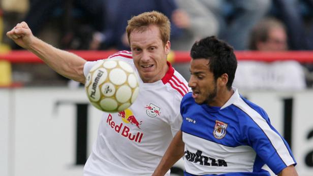 Zwei Fußballspieler kämpfen um den Ball während eines Spiels.