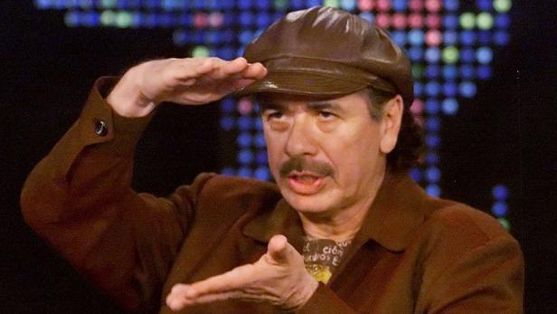 Carlos Santana gestikuliert während eines Interviews.