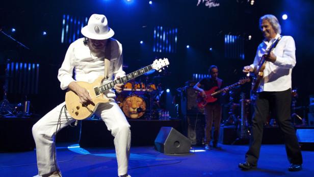 Carlos Santana spielt Gitarre während eines Konzerts mit seiner Band.