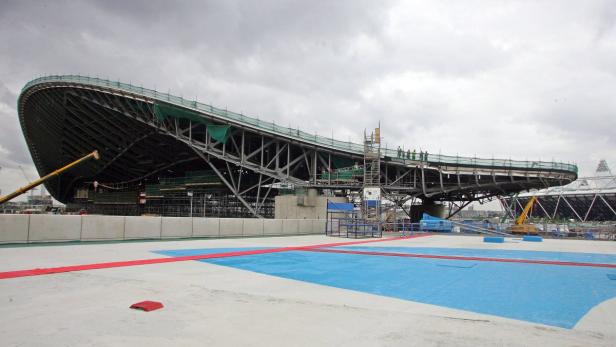 Die Baustelle des Aquatics Centre im Olympiapark London unter einem bewölkten Himmel.