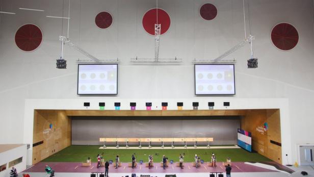 Eine Schießsportanlage mit mehreren Schützen, die auf Zielscheiben zielen.