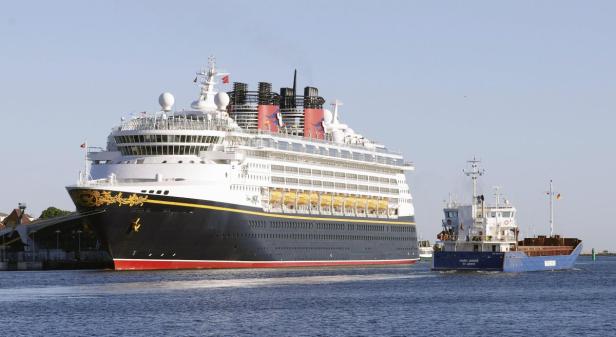 Die „Disney Magic“ liegt neben einem kleineren Frachtschiff im Hafen.