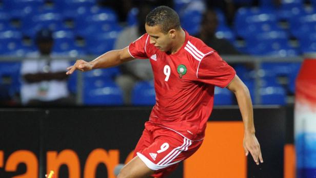Ein Fußballspieler mit rotem Trikot und der Nummer 9 auf dem Spielfeld.