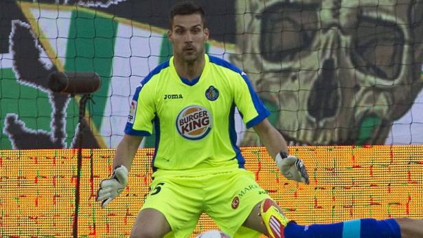 Ein Torwart in gelb-blauem Trikot steht auf dem Fußballfeld.