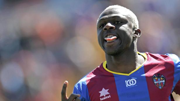 Ein Fußballspieler mit blond gefärbten Haaren streckt die Zunge heraus.