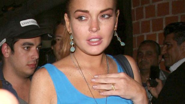 Lindsay Lohan bei einer Veranstaltung, umgeben von Menschen.