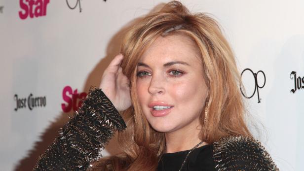 Ein Porträt von Lindsay Lohan mit blonden Haaren und einem schwarzen, verzierten Oberteil.