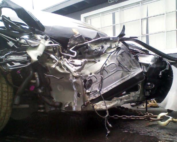 Ein schwer beschädigtes Auto wird mit einer Kette abgeschleppt.