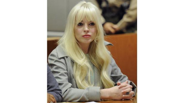 Lindsay Lohan mit blonder Perücke in einem Gerichtssaal.