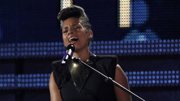 Alicia Keys singt bei einer Veranstaltung in ein Mikrofon.