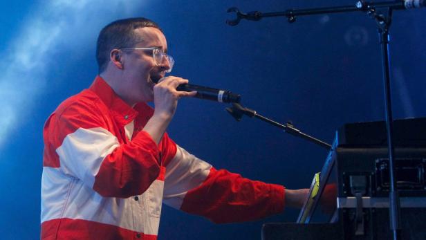 Logic tritt in einer rot-weißen Jacke bei einem Konzert auf.