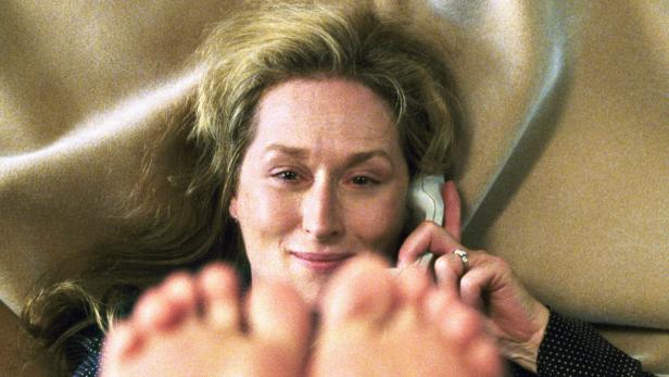 Meryl Streep liegt auf dem Sofa und telefoniert.