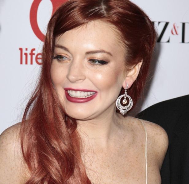 Nahaufnahme von Lindsay Lohan mit roten Haaren und Ohrringen.