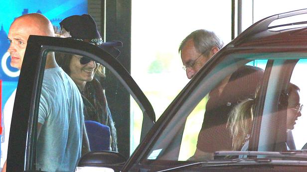 Mehrere Personen steigen in ein Auto ein oder aus.