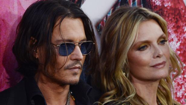 Johnny Depp und Michelle Pfeiffer posieren zusammen auf einem roten Teppich.