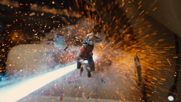 Ant-Man fliegt inmitten von Trümmern und Explosionen.