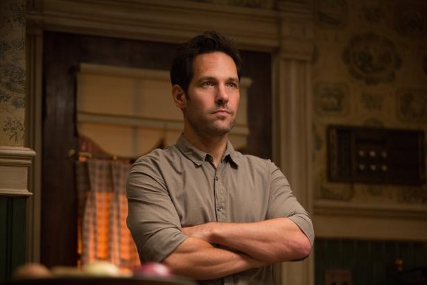 Paul Rudd steht mit verschränkten Armen in einem Raum.