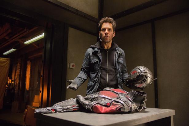 Paul Rudd steht neben dem Ant-Man-Anzug und -Helm.
