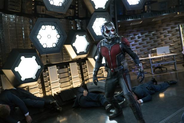 Ant-Man steht inmitten bewusstloser Männer in einem futuristischen Raum.