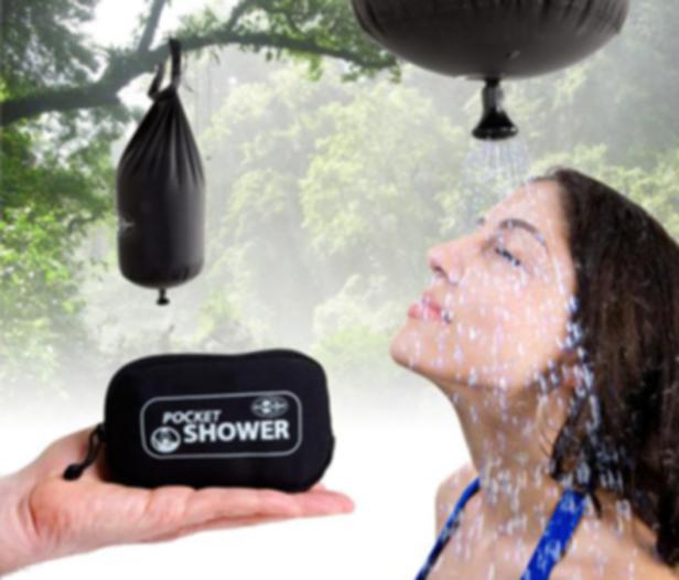 Eine Frau duscht unter einer tragbaren Outdoor-Dusche, während eine Hand die Tasche der Dusche hält.