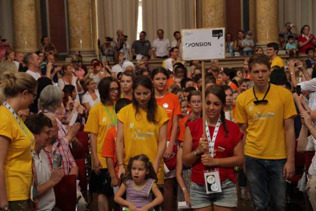 Eine Gruppe von Kindern und Erwachsenen in farbigen T-Shirts bei einer Veranstaltung.