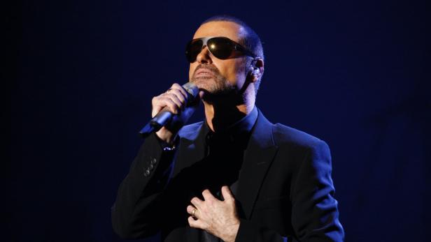 George Michael singt während eines Konzerts in ein Mikrofon.