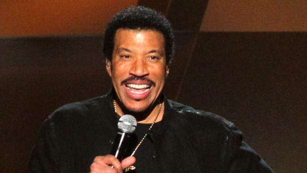 Lionel Richie singt in ein Mikrofon.