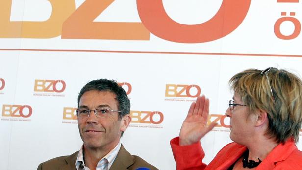 Zwei Personen stehen vor einem Hintergrund mit dem BZÖ-Logo.