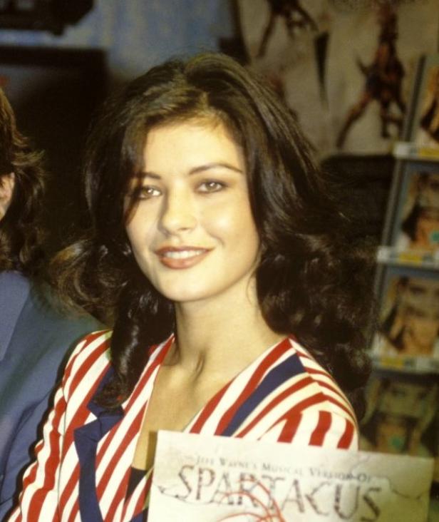 Catherine Zeta-Jones hält eine Ausgabe von „Spartacus“ in der Hand.