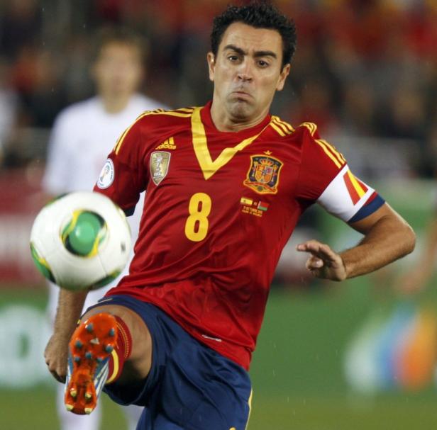 Xavi, ein spanischer Fußballspieler, schießt einen Ball.
