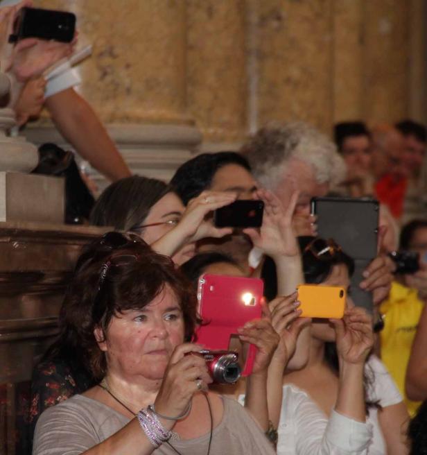 Eine Gruppe von Menschen fotografiert mit ihren Handys und Kameras.