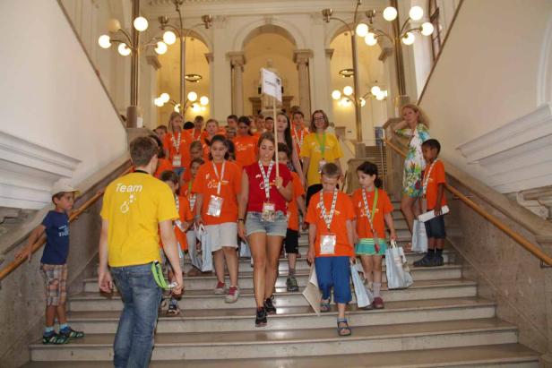 Eine Gruppe Kinder geht eine Treppe in einem Gebäude hinunter.