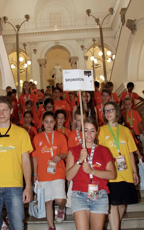 Eine Gruppe Kinder und Betreuer auf einer Treppe mit einem Schild „Sponsion“.