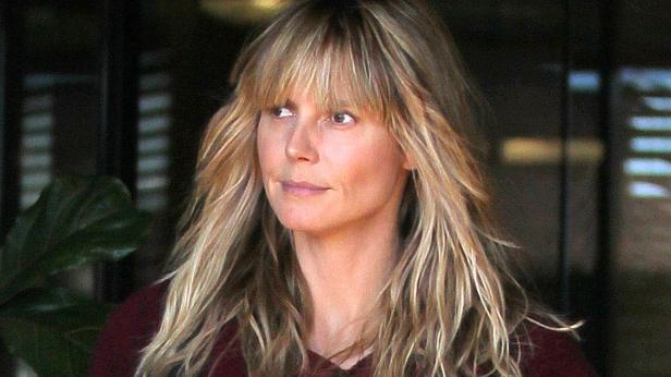 Heidi Klum mit blonden Haaren und Pony blickt zur Seite.