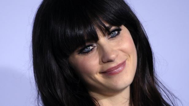 Ein Porträt von Zooey Deschanel mit dunklen Haaren und blauen Augen.