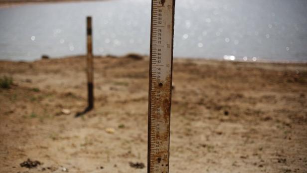 Ein Pegelstandsmesser steht am Ufer eines Sees.