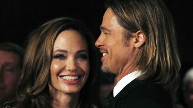 Angelina Jolie und Brad Pitt lächeln auf einem Event.