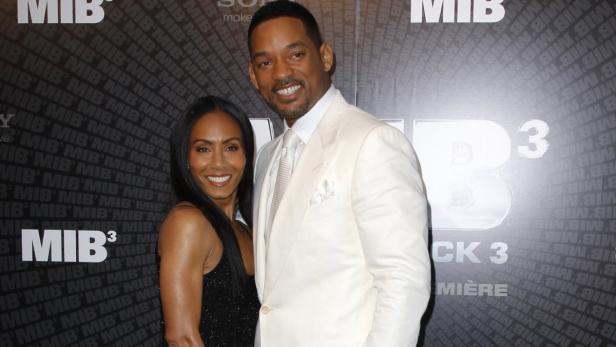 Will Smith und Jada Pinkett Smith posieren vor einer „Men in Black 3“-Werbewand.