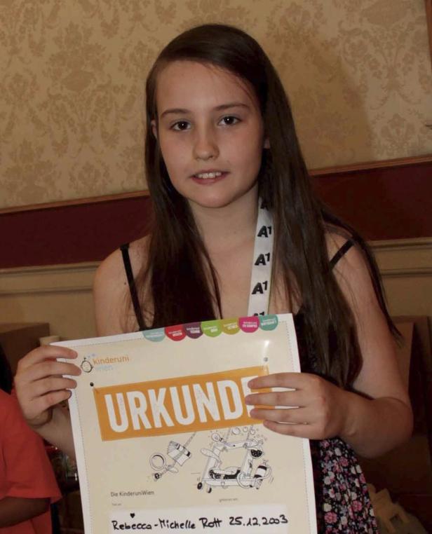 Ein junges Mädchen hält eine Urkunde der Kinderuni Wien in den Händen.