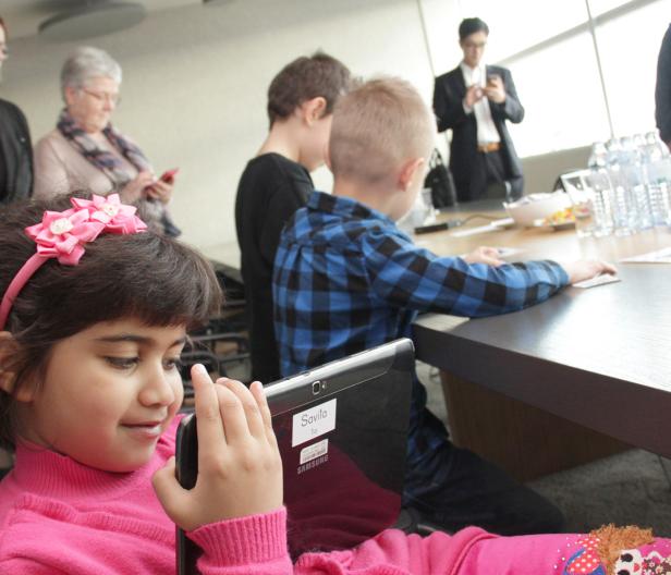Ein junges Mädchen mit einem rosa Stirnband benutzt ein Samsung-Tablet.