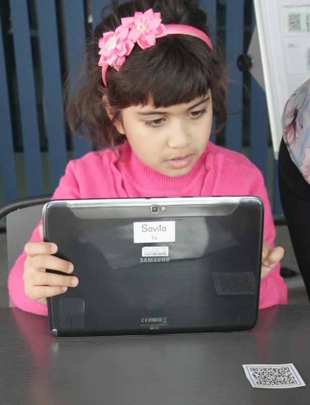 Ein Mädchen mit einem rosa Stirnband benutzt ein Samsung-Tablet.