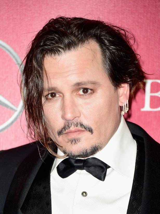 Porträt von Johnny Depp mit dunklem Haar und Bart, gekleidet in einem schwarzen Anzug mit Fliege.