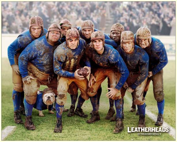 Eine Gruppe schlammbedeckter Footballspieler posiert für ein Teamfoto mit einem Bulldoggen-Maskottchen für „Ein verlockendes Spiel“.