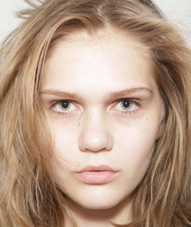 Porträt einer jungen Frau mit blonden Haaren und hellen Augen.