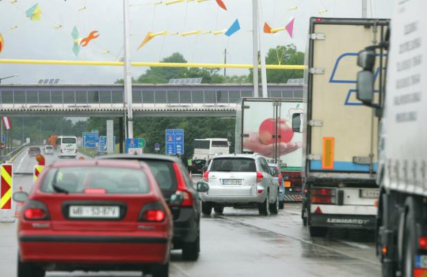 Autoverkehr staut sich auf einer Autobahn unter einer bunten Dekoration.