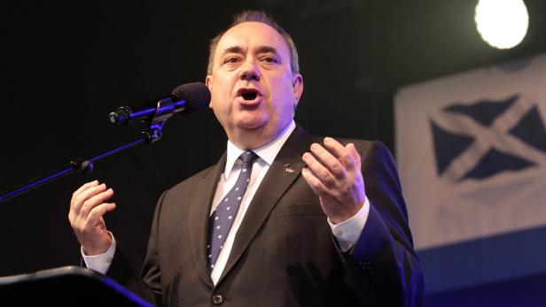 Alex Salmond hält eine Rede vor einer schottischen Flagge.