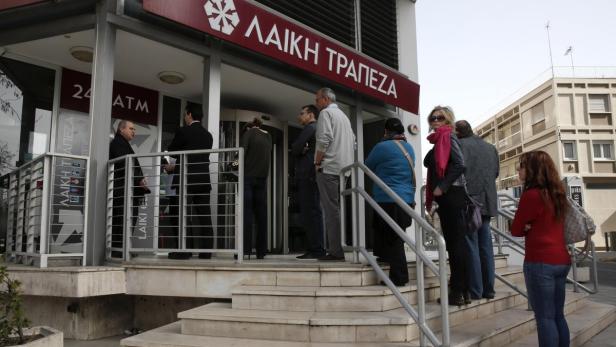 Menschen stehen vor einer Filiale der Laiki Bank Schlange.