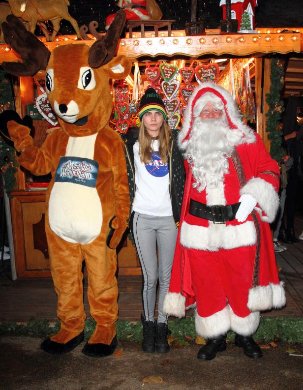 Cara Delevingne posiert mit einem Weihnachtsmann und einem Rentier auf dem Winter Wonderland Weihnachtsmarkt in London.